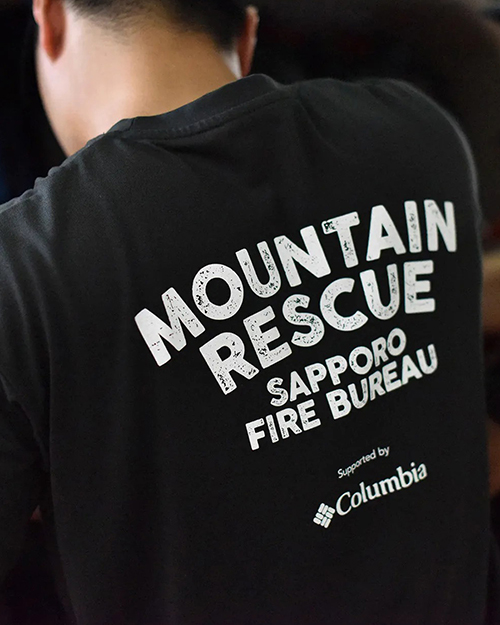 山岳救助隊の背中にMOUNTAIN RESCUE SAPPORO RIFE BUREAU supported by Columbiaと書かれている
